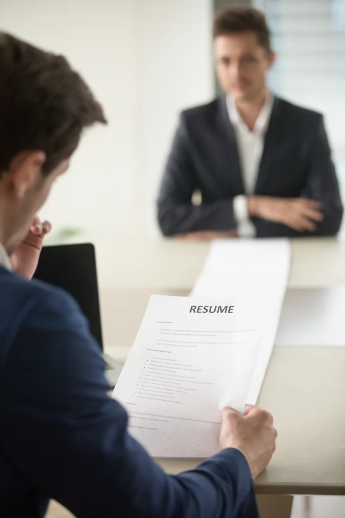 a man holding a paper with a woman in the background