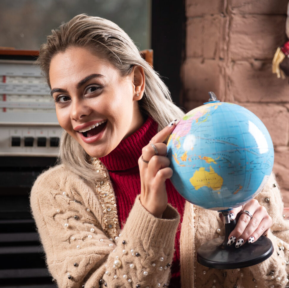 a woman smiling with a globe