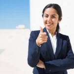 an indian woman in a suit pointing at the camera